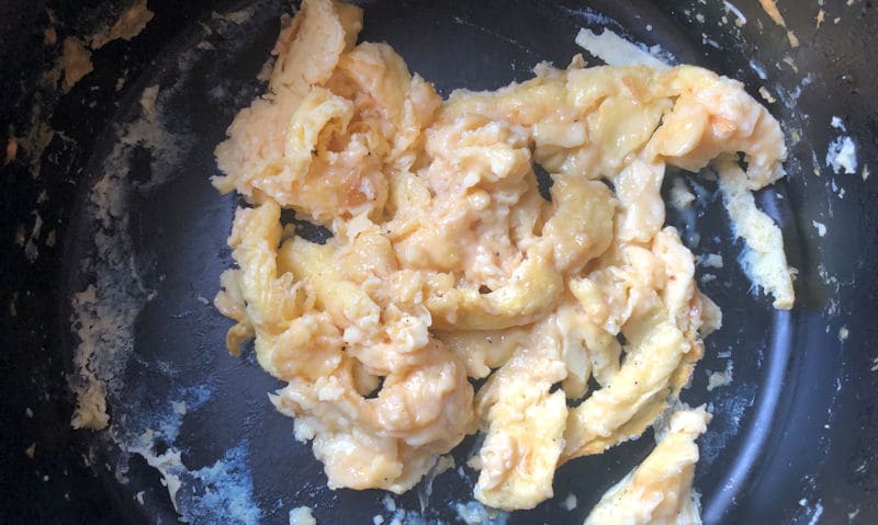 Wet scrambled eggs sat in bottom of cake tin in air fryer